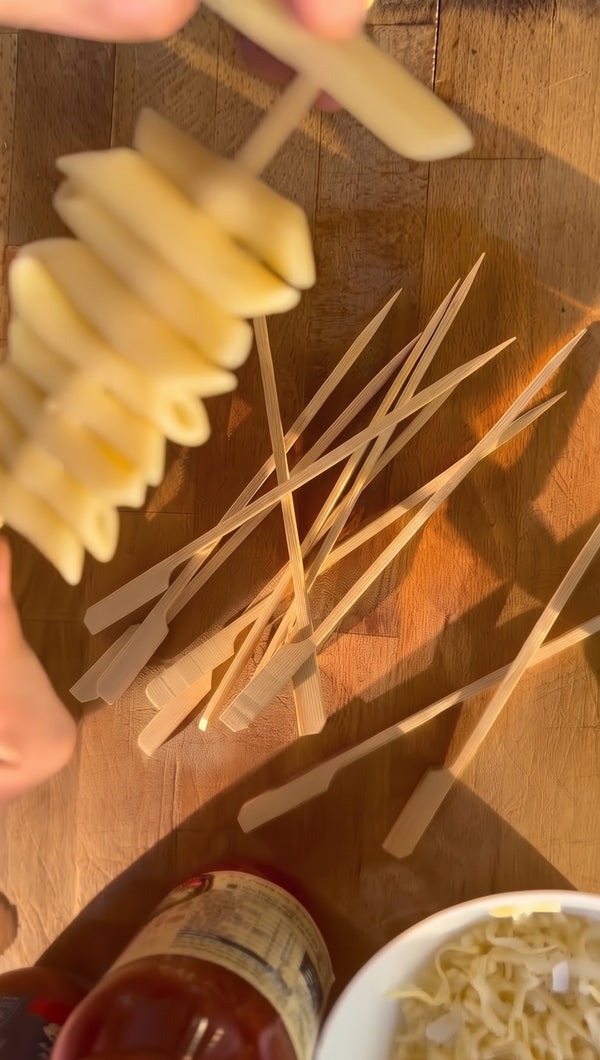 Thread pasta tubes tightly onto skewers, alternating with vegetables if desired.