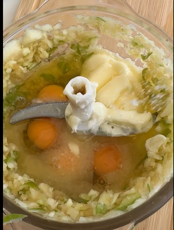 Add the eggs, sugar, vegetable oil, vanilla extract, flour, baking powder, cinnamon, and salt directly into the food processor bowl. Pulse a few times until a smooth, uniform batter forms.