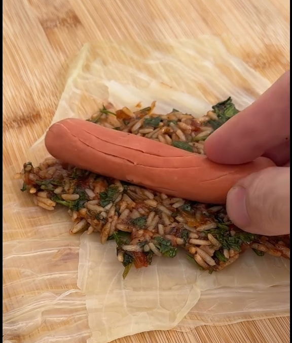 Lay each leaf flat, remove tough central rib, place filling, fold edges, and roll tightly.