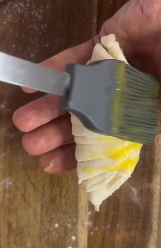 Whisk reserved egg yolk with a splash of heavy cream and brush thoroughly over croissants. Bake in preheated oven at 170°C for 15–20 minutes until golden brown and baked through.
