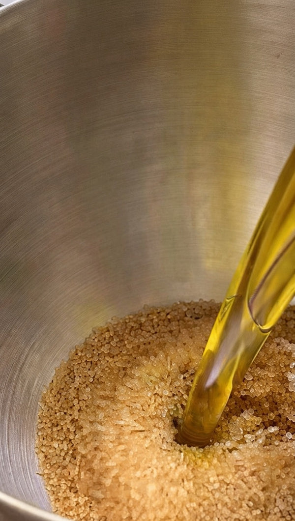 Pouring oil and liquid mixture into the brown sugar crystals.