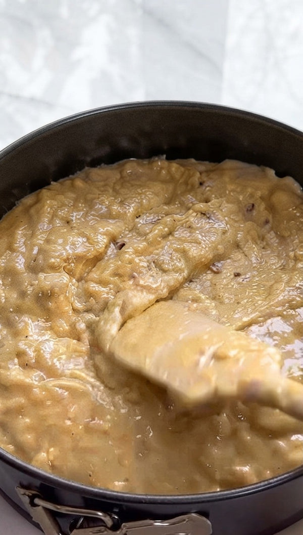 Placing halved fresh bananas at the bottom of the mixing bowl to form the fruit layer.