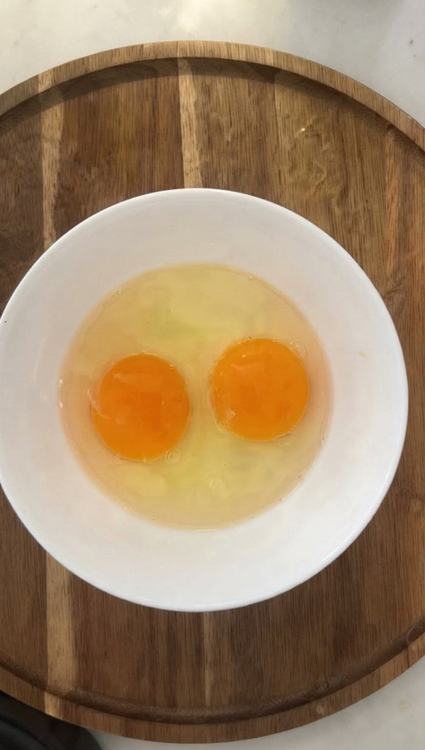 Crack fresh eggs into the bowl and incorporate them to give the batter a rich texture and proper binding.