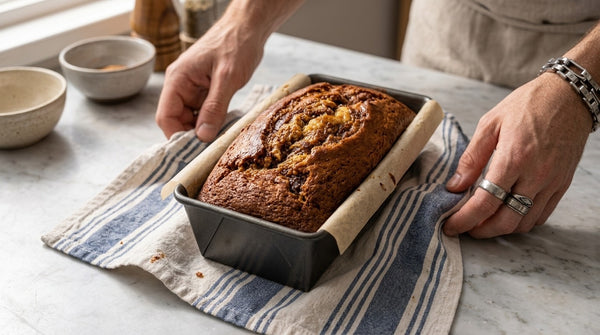Bake the loaf until it rises with a golden-brown crust, then let it rest in its pan, wrapped partly in a kitchen towel.