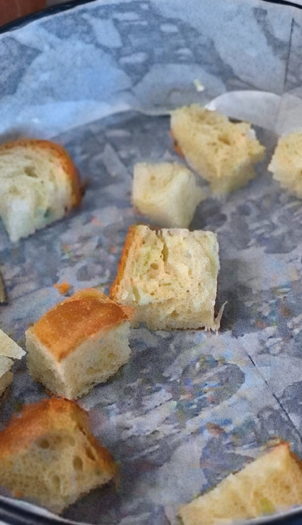 Slice fresh bread into bite-sized cubes and arrange them evenly across your baking surface.