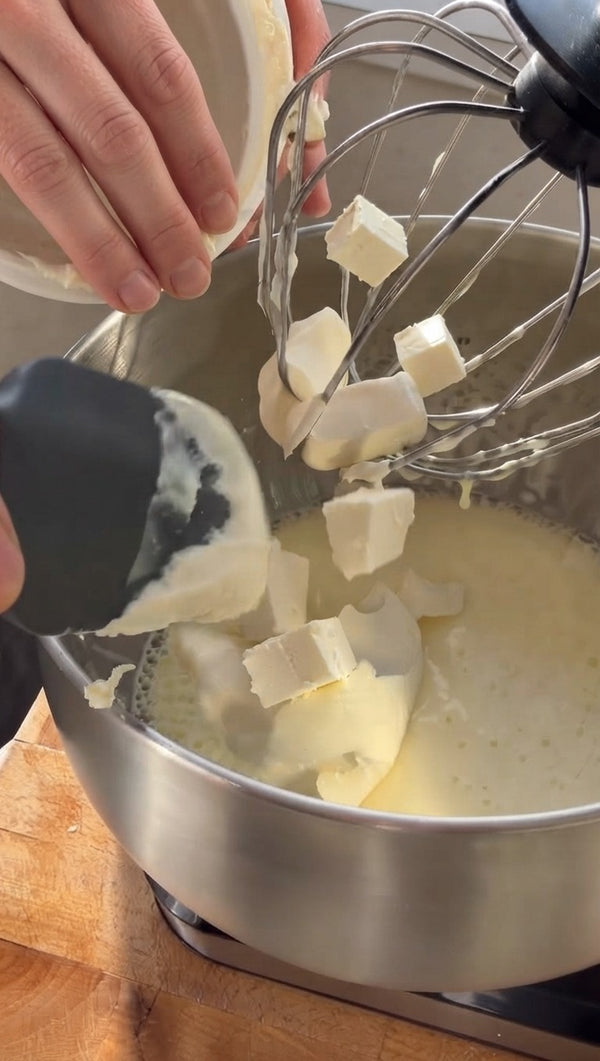 The prepared dough shards are folded into the creamy egg mixture. A spatula is used to incorporate the dry pastry into the wet base until fully combined into a dense batter.
