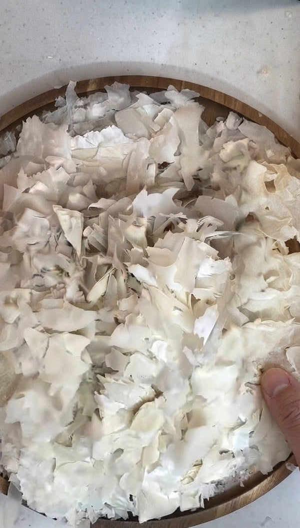Start by taking blocks or sheets of phyllo or similar pastry dough and shredding them into fine, delicate shards inside a bowl or on a tray.