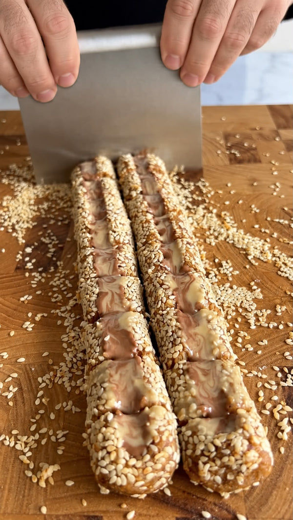 Place the dough on parchment paper or plastic wrap. Roll into a smooth log/cylinder. Coat generously on all sides with white sesame seeds, pressing lightly so they stick.