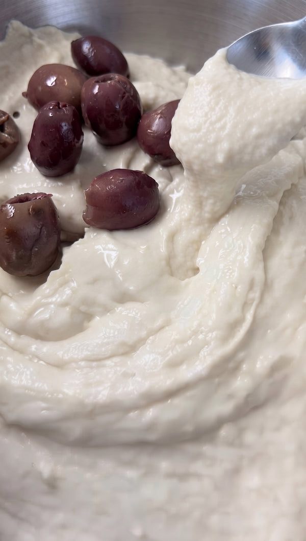 Press juices into dough.
Press halved cherry tomatoes cut-side down, black olives, and fresh oregano into the dough, creating deep dimples. Cover and allow to rest/proof for another 30 minutes.