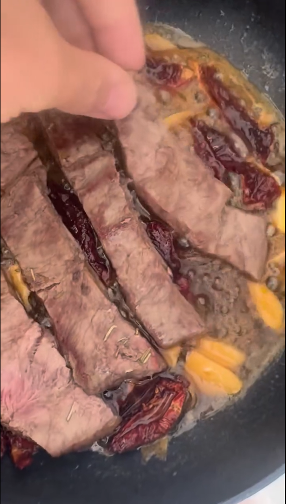 Sweet and tangy balance. In the same meat pan, sprinkle 1 tbsp sugar and allow it to melt into a golden caramel. Carefully deglaze with apple cider vinegar, then add white wine, water, sliced garlic, chili flakes, and chopped sun-dried tomatoes. Simmer until reduced and glossy.