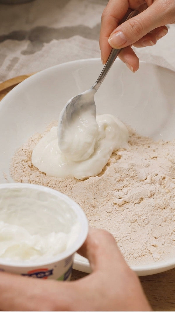Mix raw tahini and goat yogurt until unified. Add lemon juice, minced garlic, salt, and pepper. Slowly whisk in cold water until smooth, creamy, and pourable.