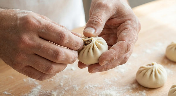 Place 1 rounded teaspoon of filling in the center of each wrapper. Moisten the edges with water, pleat the edges clockwise, and pinch firmly at the top to seal completely.