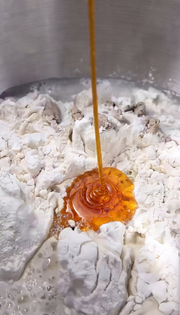 Crush sweet cherry tomatoes directly over the dough with your hands, sinking juices and skins into the dough pockets. Scatter black olives, oregano, and coarse sea salt.