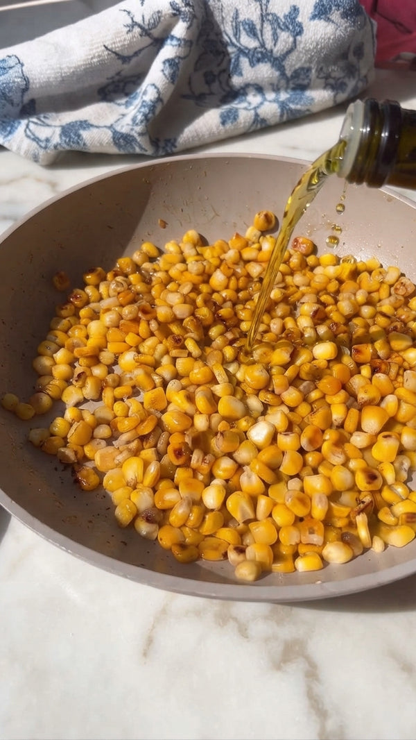 In a deep pan or wok, heat oil. Add minced garlic and grated ginger, sautéing for 1 minute until fragrant. Add the whole corn kernels and cook for 2-3 minutes until lightly charred.