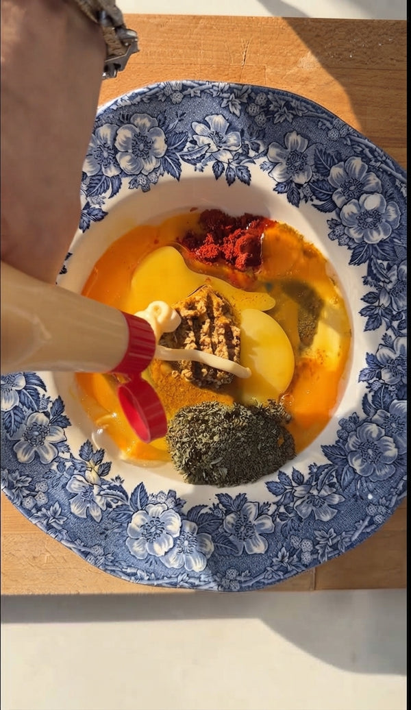 Dip thin chicken breast strips into seasoned egg batter, ensuring complete coverage. Place each strip onto kadaif strands and press gently to coat completely on all sides.