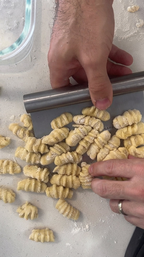 Divide into 3–4 portions. Roll each piece gently into a long rope. Cut into small bite-sized pillows and place on a floured surface.