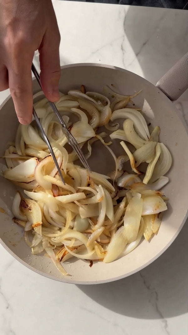 Heat olive oil and butter in a wide pan over medium heat. Add sliced onions and cook slowly for 25–30 minutes, stirring regularly, until deeply caramelized, sweet, and golden brown. Season with salt and pepper.