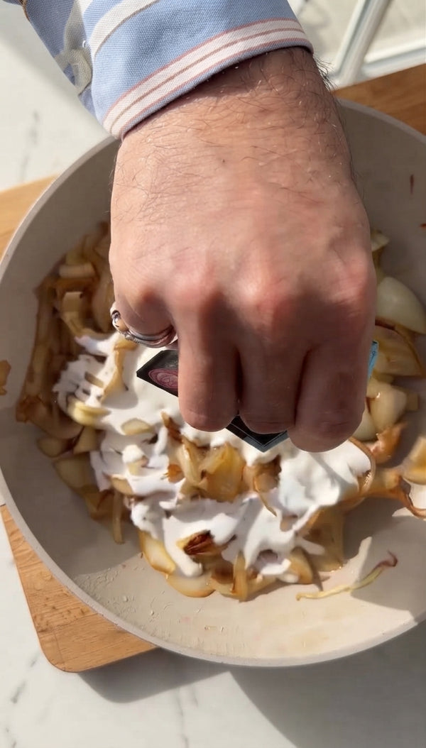 Add heavy cream and pasta water to caramelized onions. Simmer 3-4 minutes until rich and velvety.