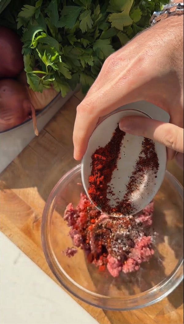Season ground beef with cumin, smoked paprika, garlic powder, salt, and black pepper. Divide into equal portions and smash thinly onto the outer or inner surface of halved pita pockets, pressing firmly to adhere.