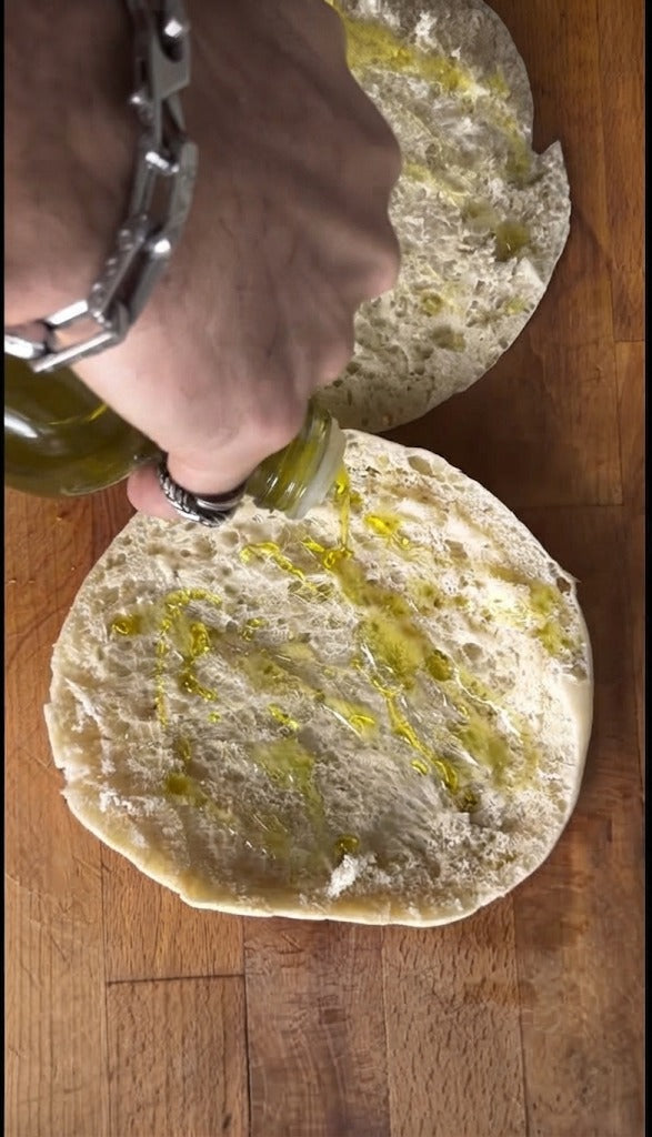 Сбрызните поверхность сырой курицы несколькими каплями оливкового масла — это обеспечит лучшее сцепление мяса с питой.