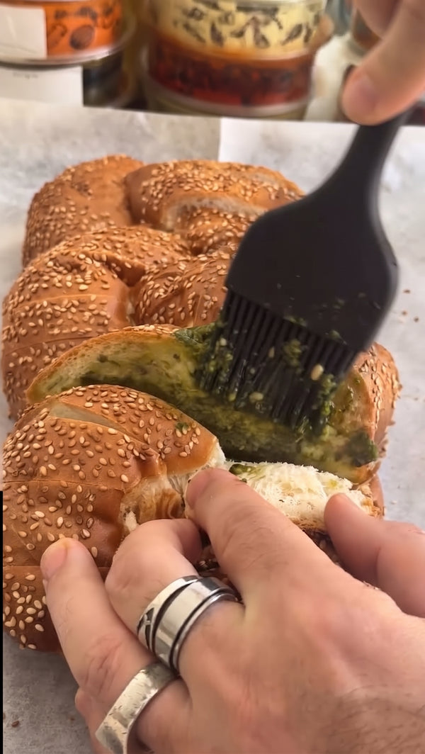 Drizzle or brush melted garlic butter deep into all the crevices. Spread small spoonfuls of pesto or tapenade between the slices.