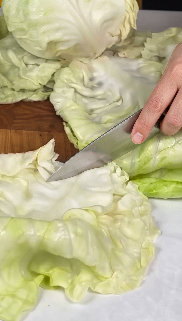 Wrap whole cabbage in plastic wrap and microwave on high for 15 minutes until pliable.