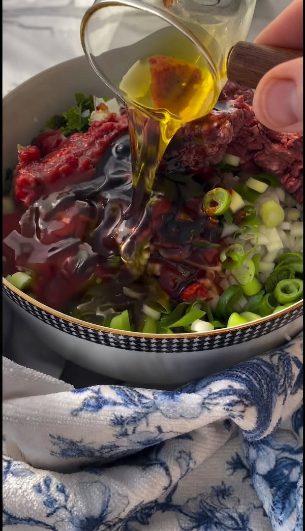 Whisk olive oil, silan, pomegranate molasses, soy sauce, crushed garlic, sweet paprika, salt, and black pepper in a small bowl.