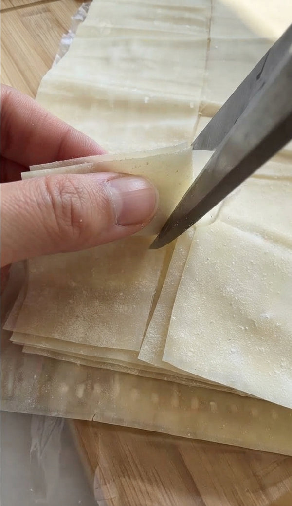 Place a spoonful of cheese filling at the bottom corner of a strip. Fold diagonally to form a triangle, then continue folding triangle-over-triangle along the strip until sealed.